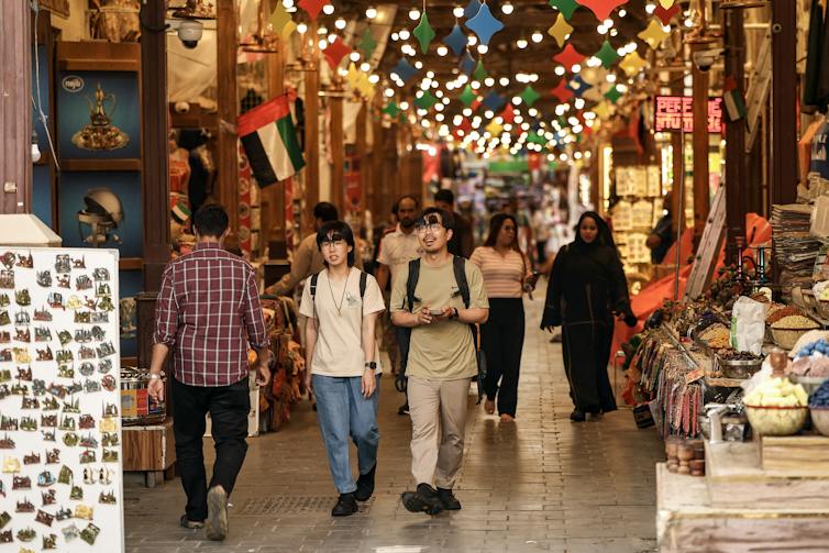 Tourists walk in a market in Dubai
